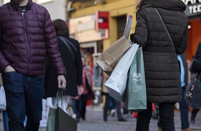 Archivo - Varias personas con bolsas de la compra en una calle céntrica. A 04 de enero de 2023, en Sevilla (Andalucía, España). 