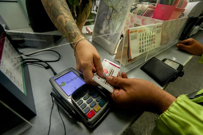Archivo - Un viajero carga su tarjeta Renfe con el abono gratuito, en la estación de Chamartín