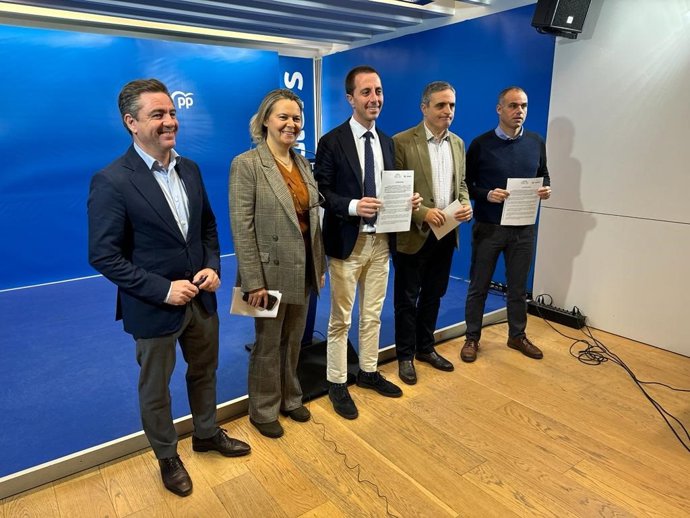 El presidente del PP de Mallorca, Lloren Galmés, junto a diputados y senadores 'populares' sosteniendo la moción registrada en el Senado sobre el convenio de carreteras.
