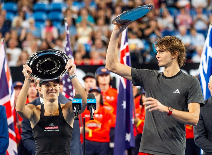 Archivo - 05 January 2019, Australia, Perth: German tennis players Angelique Kerber and Alexander Zverev hold the trophies up for second place after losing against Swiss Roger Federer and Belinda Bencic during the mixed doubles final match between Germa