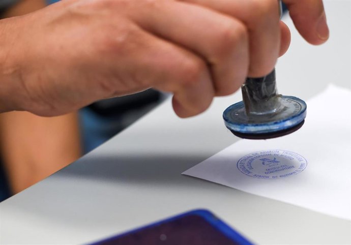 Archivo - Un empleado público pone un sello de la Agencia Tributaria.