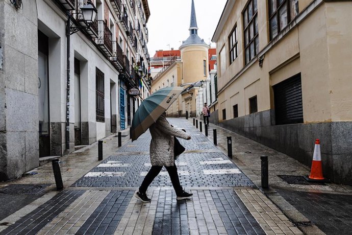 Archivo - Una mujer se protege de la lluvia con un paraguas, a 2 de noviembre de 2023, en una foto de archivo 