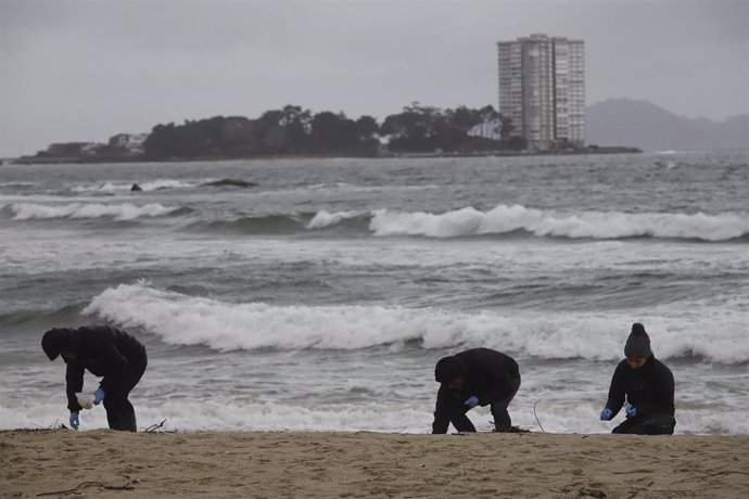 Voluntarios limpian pellets en la playa de Samil, a 10 de enero de 2024, en Vigo, Pontevedra, Galicia.