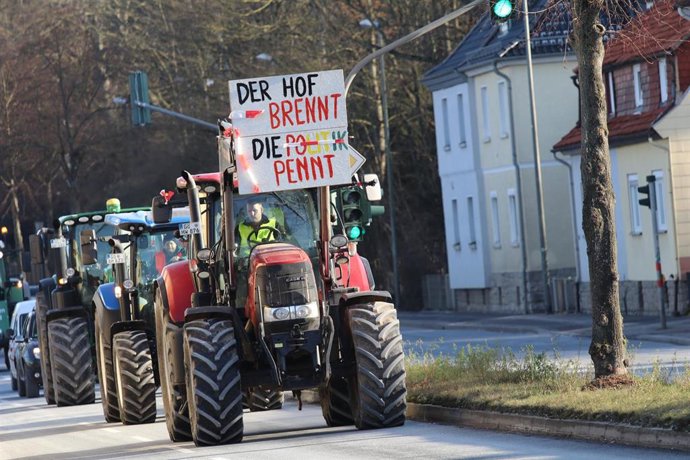 Archivo - Agricultores alemanes bloquean el tráfico con sus tractores en protesta por la reducción de ayudas del Gobierno