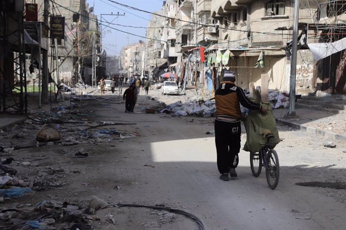 GAZA, Jan. 10, 2024  -- People walk past damaged buildings in Gaza City, on Jan. 10, 2024. At least 147 Palestinians were killed in the Israeli attacks across the Gaza Strip in the past 24 hours, raising the death toll in the enclave to 23,357 since the