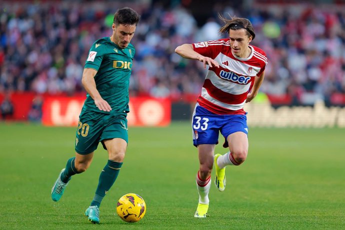 Iza Carcelen of Cadiz CF and Alvaro Carreras of Granada CF in action during the Spanish league, La Liga EA Sports, football match played between Granada CF and Cadiz CF at Nuevo Los Carmenes stadium on January 3, 2024, in Granada, Spain.