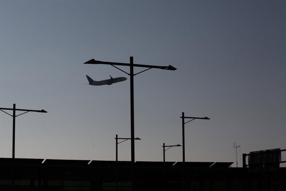 Archivo - Un avión sobrevuela el Aeropuerto de Barcelona-El Prat