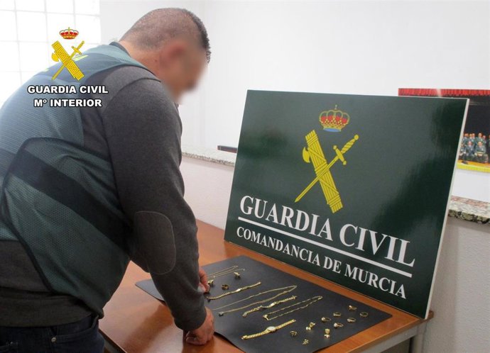 Un agente de la Guardia Civil junto a las joyas recuperadas