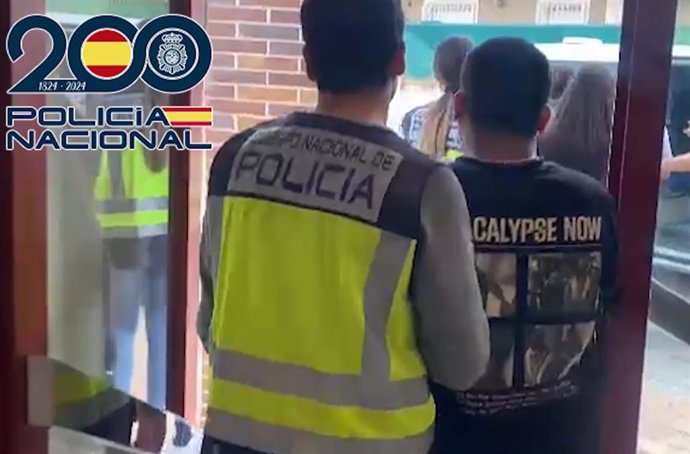 Un agente junto a uno de los detenidos