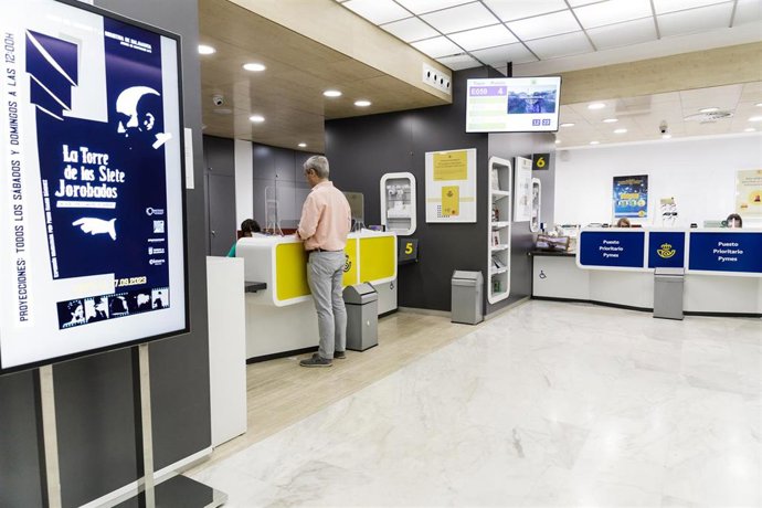 Archivo - Un hombre es atendido en la oficina de Correos. Imagen de archivo. 