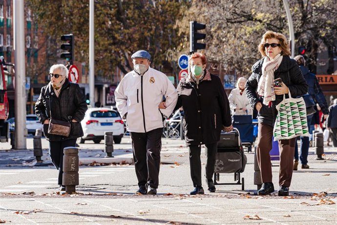 Varias personas con mascarilla paseando por la calle.