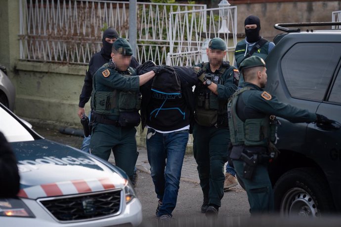 Diversos agents de la Guàrdia Civil porten a un detingut després d'una operació policial antiyihadista en un habitatge, a 16 de gener de 2024, a Martorell, Barcelona, Catalunya (Espanya). 