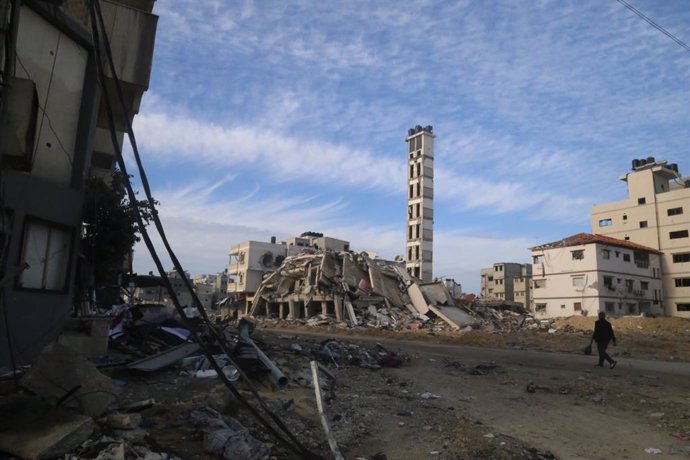 GAZA, Jan. 16, 2024  -- A person walks past destroyed buildings in Gaza City, on Jan. 15, 2024. The Palestinian death toll from ongoing Israeli attacks on the Gaza Strip has risen to 24,285, the Gaza-based Health Ministry said on Tuesday.