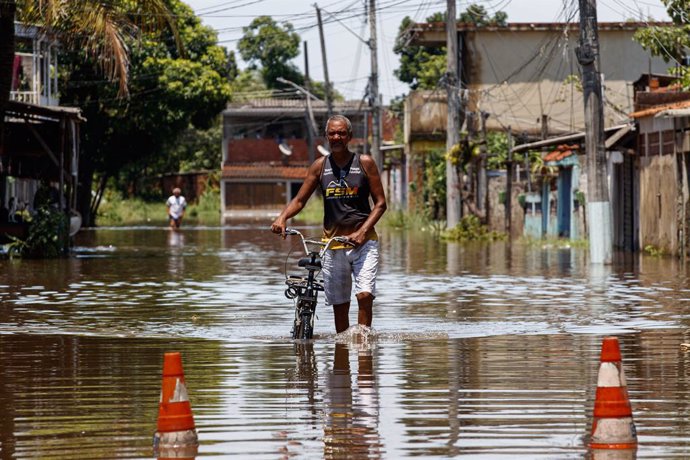 RIO DE JANEIRO, Jan. 16, 2024  -- A resident walks through a flooded road in Lote XV, Belford Roxo, Rio de Janeiro, Brazil, Jan. 15, 2024. The death toll from the storm that hit the southeastern Brazilian state of Rio de Janeiro on Sunday has risen to 1