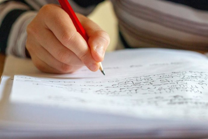 Una persona escribiendo sobre un papel