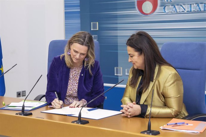 La presidenta del Colegio de Farmacéuticos de Cantabria, Rita de la Plaza (i), y la consejera de Inclusión Social, Begoña Gómez del Río (d), firman un convenio de colaboración para actuar contra la soledad no deseada