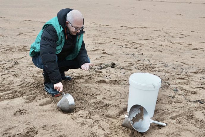Archivo - Un voluntario recoge pellets en la playa de La Arena, a 10 de enero de 2024, en Muskiz, Vizcaya, País Vasco (España). Ayer, 9 de enero, se detectó la presencia de pellets en la playa vizcaína de La Arena. Después de localizarse estos microplásti