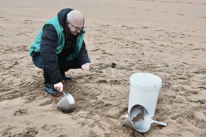 Archivo - Un voluntario recoge pellets en la playa de La Arena, a 10 de enero de 2024, en Muskiz, Vizcaya, País Vasco (España). Ayer, 9 de enero, se detectó la presencia de pellets en la playa vizcaína de La Arena. Después de localizarse estos microplás