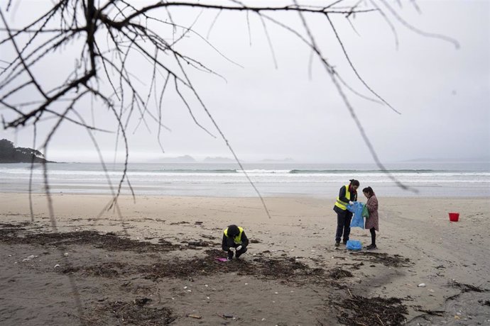 Archivo - Voluntarios durante una limpieza de pellets, en la playa de Patos, a 15 de enero de 2024, en Nigrán Pontevedra, Galicia (España), en una foto de archivo 
