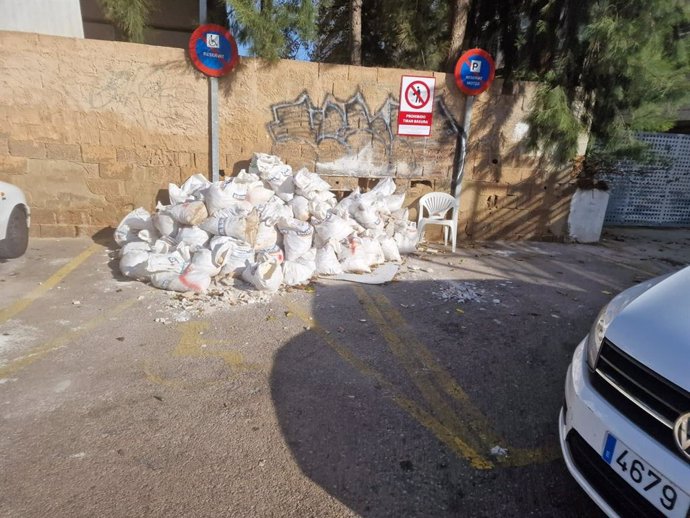 Escombros de una obra depositados en una plaza reservada para personas con movilidad reducida.