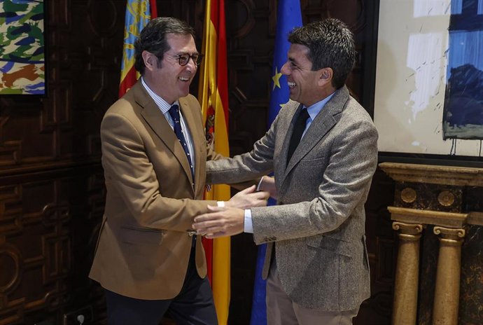 El presidente de la Confederación Española de Organizaciones Empresariales (CEOE), Antonio Garamendi (i), saluda al president de la Generalitat, Carlos Mazón (d), a su llegada a una reunión en el Palau de la Generalitat
