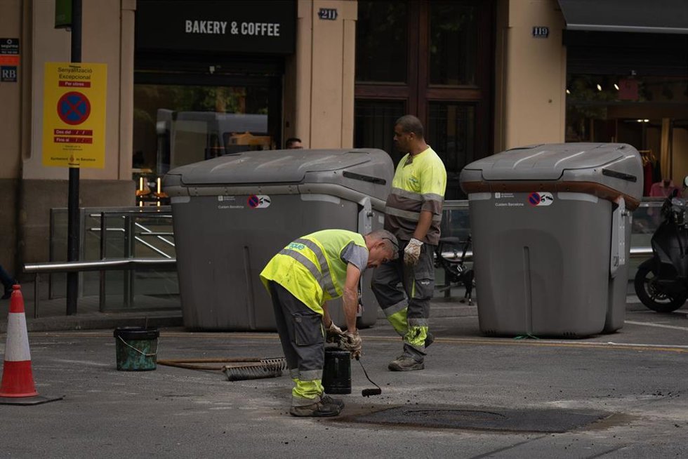 Archivo - Varios operarios asfaltan un tramo de carretera, a 10 de mayo de 2023, en Barcelona