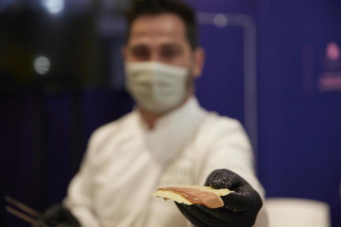 Archivo - Una persona ofrece jamón con queso en la XXXIV edición del Salón Gourmets en IFEMA