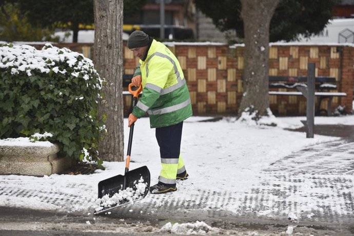 Un home retira la neu d'una calada