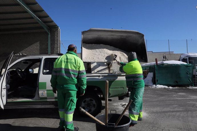 Archivo - Dos empleados de Limpieza y Zonas Verdes recoge sal con una excavadora para llevarla en un vehículo de Medio Ambiente