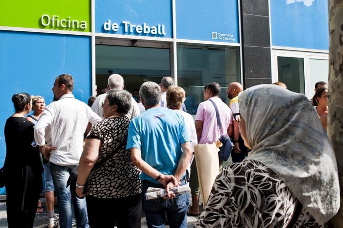 Archivo - Personas esperando ante una oficina del SOC