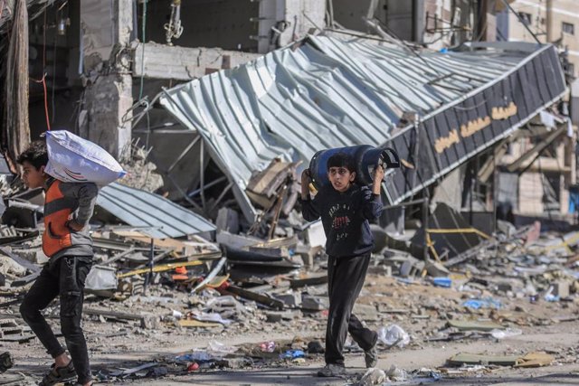 Un niño transporta una bombona en el campo de refugiados de Nuseirat, en la Franja de Gaza