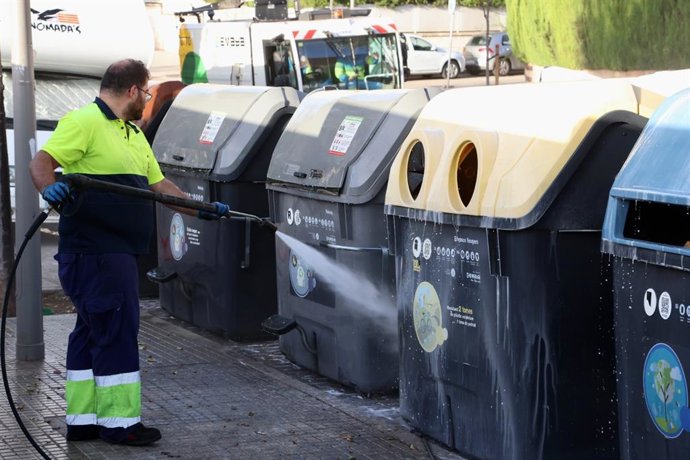 Archivo - Técnico de Emaya limpiando los contenedores con agua a presión