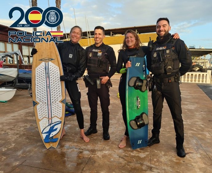 Agentes de la Policía Nacional con las kitesurfistas rescatadas