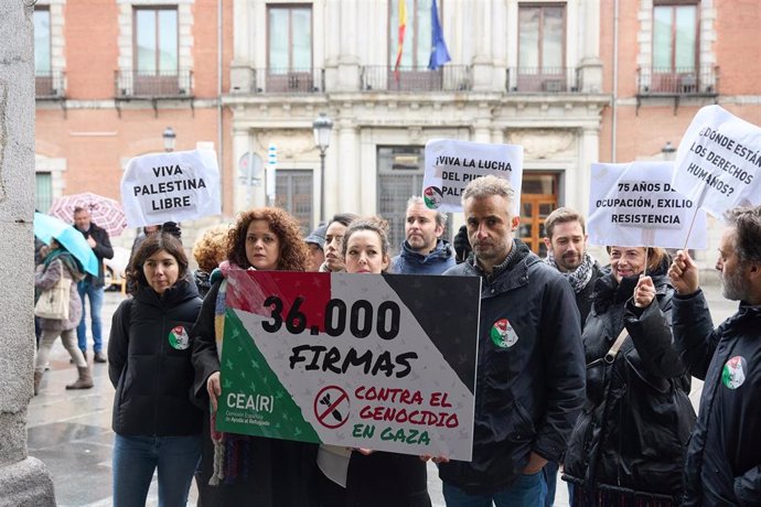 Varias personas sujetan una pancarta de 36.000 firmas durante el acto de entrega de firmas ciudadanas de la Comisión Española de Ayuda al Refugiado (CEAR), frente al Ministerio de Asuntos Exteriores, a 19 de enero de 2024, en Madrid (España). 