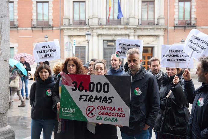 Varias personas sujetan una pancarta de 36.000 firmas durante el acto de entrega de firmas ciudadanas de la Comisión Española de Ayuda al Refugiado (CEAR), frente al Ministerio de Asuntos Exteriores, a 19 de enero de 2024, en Madrid (España). CEAR entrega