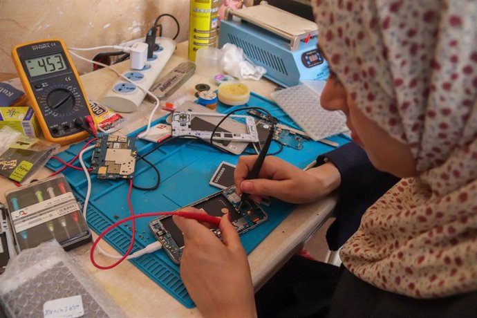 Archivo - Una joven repara teléfonos móviles en Gaza 