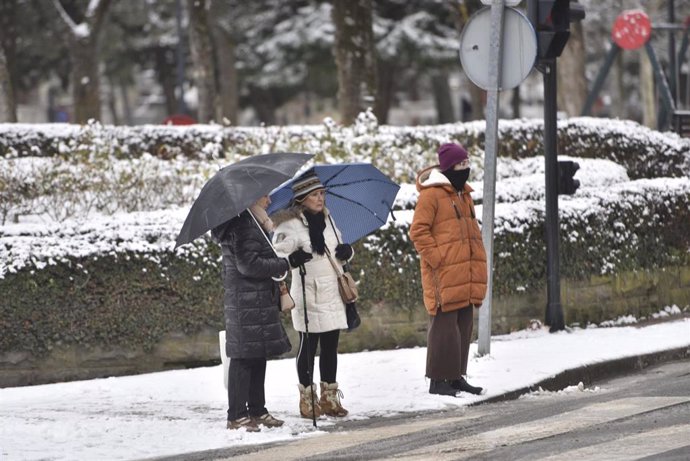 Dos mujeres sujetan un paraguas en una acera llena de nieve, a 10 de enero de 2024, en Jaca, Huesca, Aragón (España). 