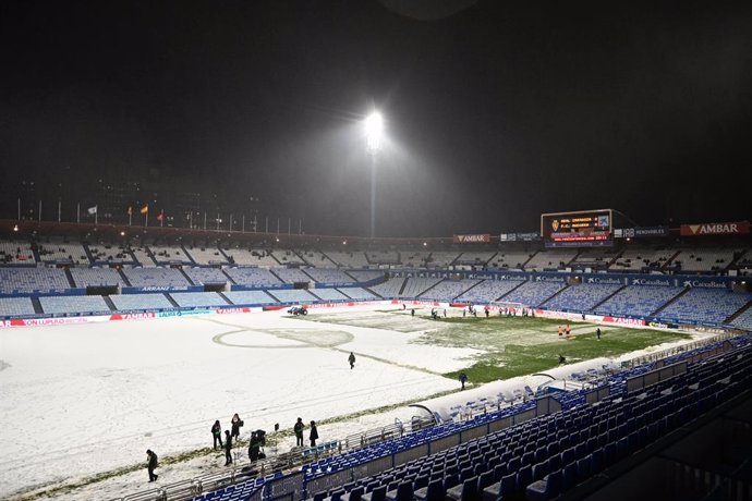 La nieve cubre el césped del estadio del Real Zaragoza, la Romareda, a 19 de enero de 2024, en Zaragoza, Aragón (España). El encuentro, planificado para este viernes 19 de enero a partir de las 20.30, se atrasó primero y se suspendió después tras la inspe