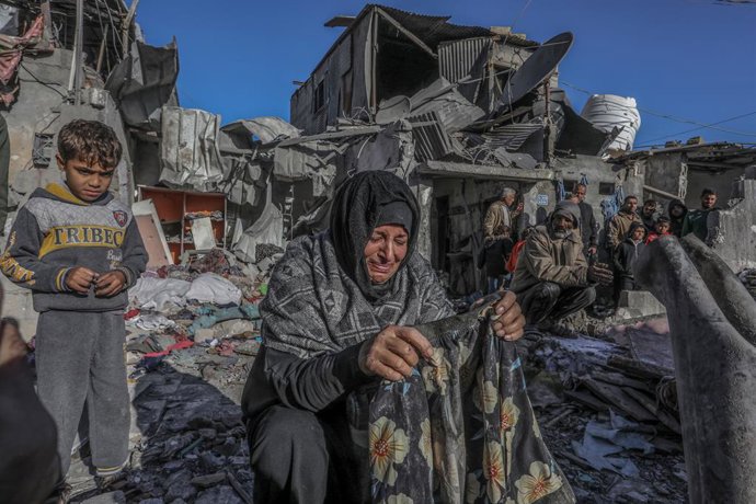 18 January 2024, Palestinian Territories, Rafah: A Palestinian woman cries as she inspects damages after an Israeli air strike on a house belonging to the Zamili family in the city of Rafah in the southern Gaza Strip. 16 people were killed, according to