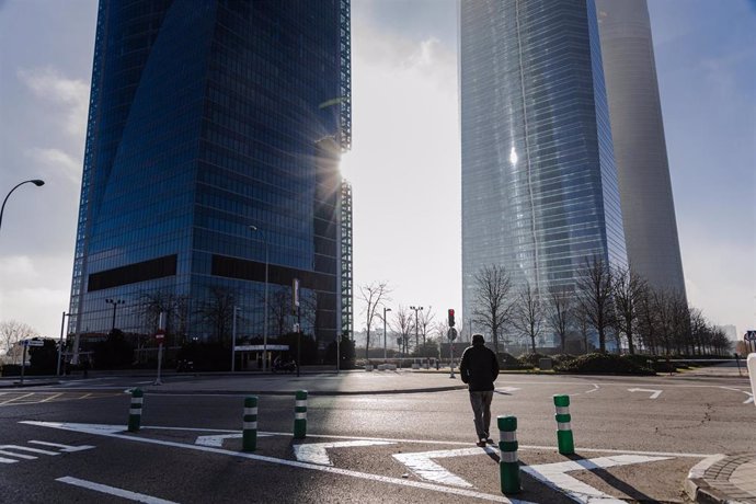 Un hombre camina hacia las Torres de la Castellana, a 1 de enero de 2024, en Madrid (España).