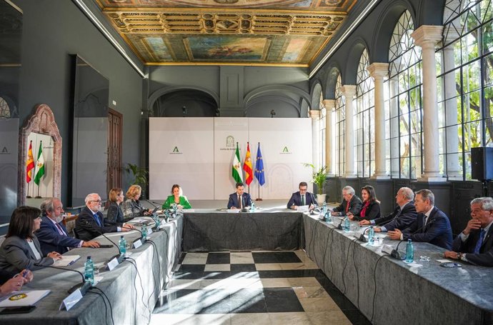 El presidente de la Junta de Andalucía, Juanma Moreno (c); junto al presidente del Consejo Andaluz de Colegios Médicos, Jorge Fernández Parra (d); y la consejera de Salud y Consumo, Catalina García (i); junto a los demás miembros del Consejo, al inicio 