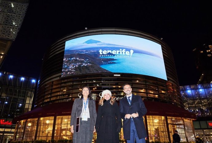 La consejera delegada de Turismo de Tenerife, Dimple Melwani, la presidenta del Cabildo, Rosa Dávila y el vicepresidente, Lope Afonso, junto a un mural promocional de la isla