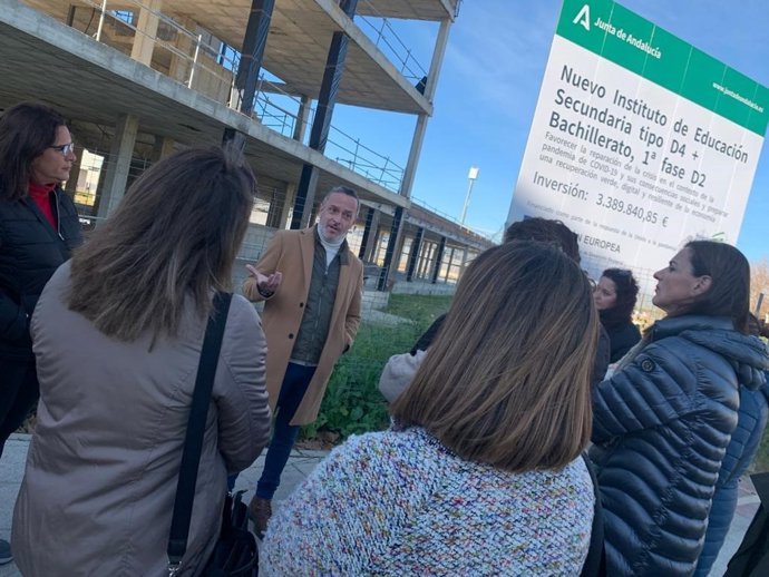 El secretario de organización del PSOE de Sevilla y parlamentario andaluz, Rafael Recio, con familias de Dos Hermanas, frente a la obra "paralizada" de un instituto público en el municipio de Dos Hermanas.
