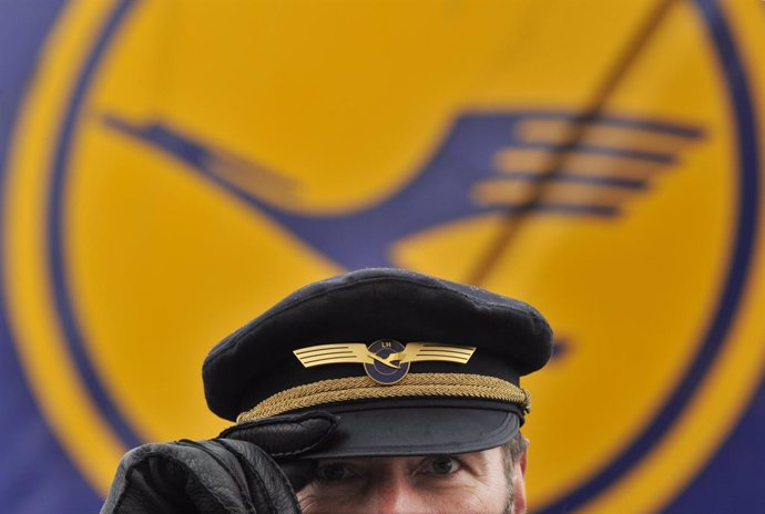 Archivo - FILED - 22 February 2010, Frankfurt/Main: A Lufthansa pilot stands in front of the Lufthansa logo at Frankfurt Airport. Photo: picture alliance / Boris Roessler/dpa