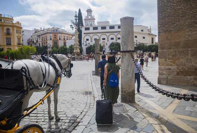 Archivo - Imagen de recurso de turistas junto a la Giralda, en la Plaza Virgen de los Reyes.