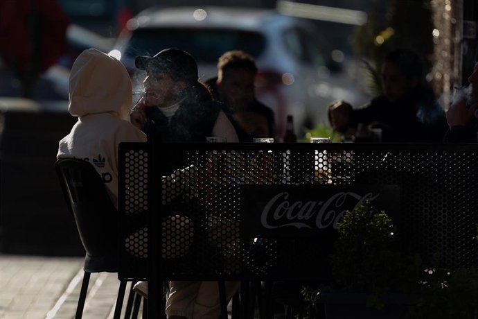 Una persona fumando en una terraz