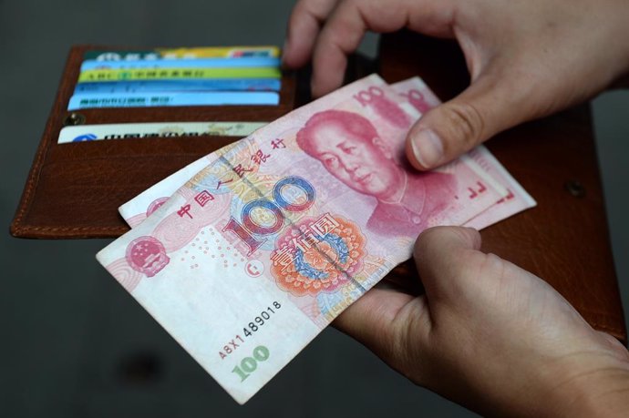 Archivo - FILED - 30 August 2015, China, Shanghai: A woman holds Chinese Yuan banknotes. Photo: Jens Kalaene/dpa-Zentralbild/dpa