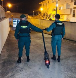 Agentes de la Guardia Civil con uno de los patinetes sustraídos.