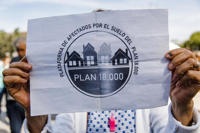 Archivo - Una persona sujeta una pancarta durante una protesta sobre el Plan 18000 Venta de Suelo 