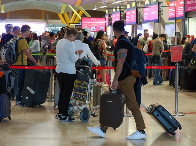 Archivo - Varias personas con maletas en el Aeropuerto Adolfo Suárez-Madrid Barajas, en Madrid (España)